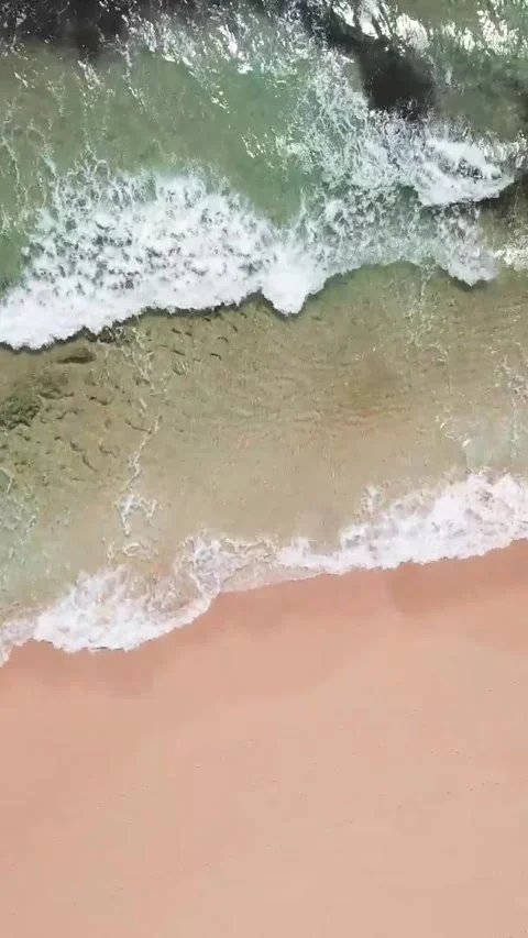 Beautiful aerial top-down view of turquoise ocean waves gently rolling onto a Stock Footage 344820498