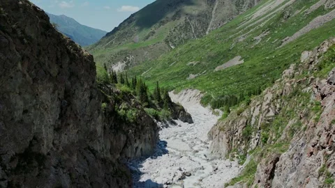 Beautiful aerial view of a deep mountain gorge with rocky slopes and green hills Stock Footage 327631548
