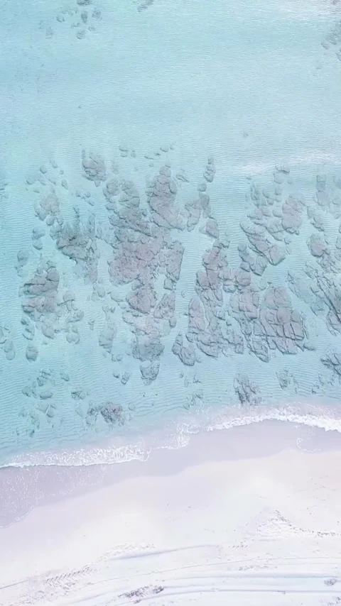 Beautiful aerial view of a pristine tropical beach with white sand and clear Stock Footage 344396150
