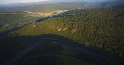 Beautiful aerial view of the train moving by rail, next to the river at sunset Stock Footage 104470737