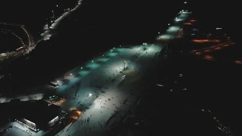 Beautiful aerial view of winter ski resort and skiers on the slopes at night Stock Footage 148564758