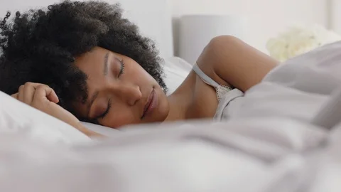 Beautiful african american woman waking up in bed after restful sleep smiling Stock Footage