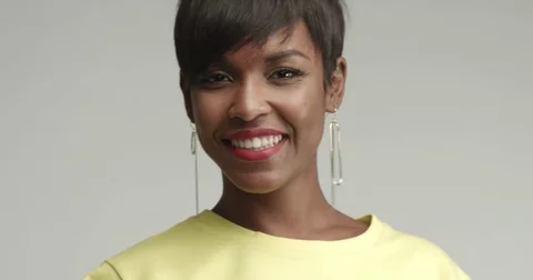 Beautiful African woman with large earrings in yellow top Stock Footage
