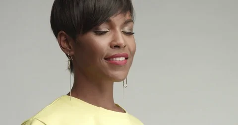 Beautiful African woman with large earrings in yellow top Stock Footage