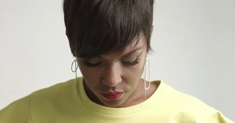 Beautiful African woman with large earrings in yellow top Stock Footage