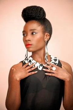 Beautiful African woman with natural hairstyle posing looking sideways  Stock Photos