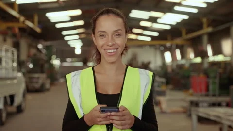 Beautiful african worker American is using a cell phone in a factory workshop Stock Footage