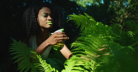 The beautiful afro-american woman with bright green make-up is looking after the Stock Footage
