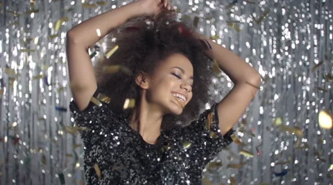Beautiful afro american woman dancing among golden confetti, slow motion. Stock Footage