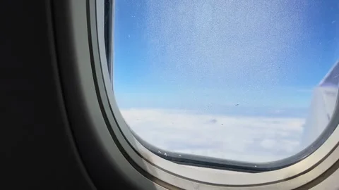 Beautiful airplane window view of clouds and sky during flight, ideal for Stock Footage 342899581