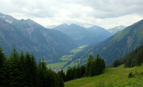 Beautiful alpine landscape with green meadows, alpine cottages and mountain p Stock Photos