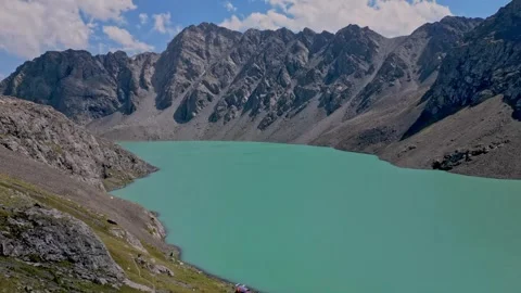 Beautiful Alpine Scene Featuring Peaceful Turquoise Lake With Sunlit Cliffs And Stock-Footage 339079291