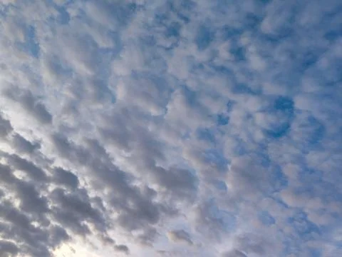 Beautiful altocumulus clouds pattern spreading across a clear blue sky Foto stock