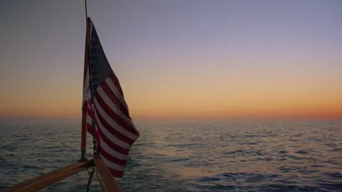 The beautiful American Flag waves at sunset atop a majestic sailing ship Vidéo 306623880