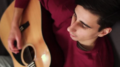 Beautiful And Cute Guy Playing Guitar. Top view. Stock-Footage 59728858