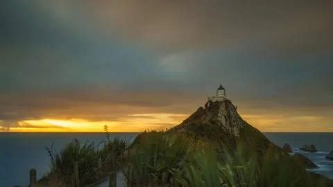 Beautiful And Dramatic Long Exposure Shot Of Sunrise At Nugget Point Lighth.. Stock Photos
