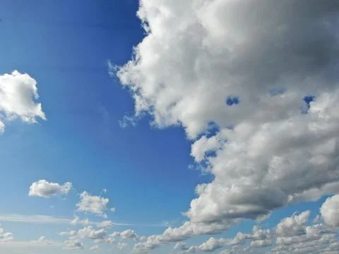 Beautiful and dramatic white fluffy clouds in a deep blue sky Stock Photos