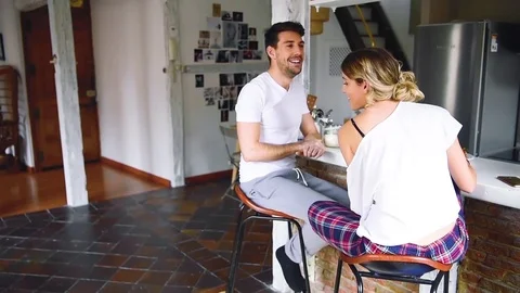 Beautiful and happy couple having breakfast together in modern apartment. Stock Footage 74727770