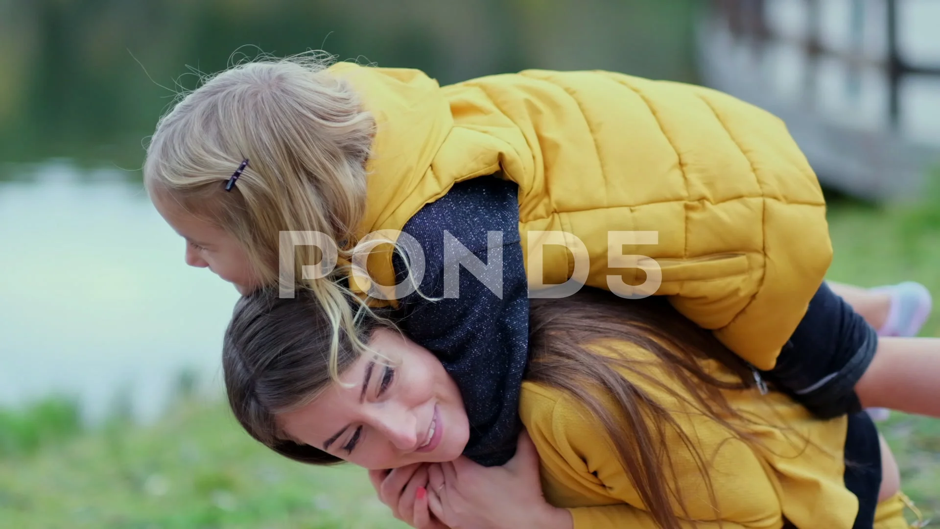 Happy mother giving her son a piggyback ride in the city stock photo