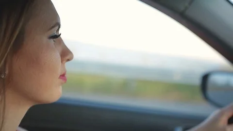 Beautiful and sexy girl in red dress rides behind the wheel of a car Stock Footage