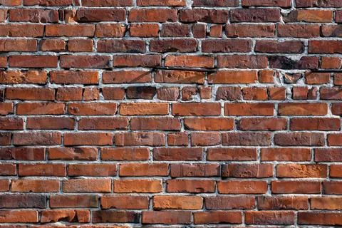 Beautiful and uniform pattern of a built old wall of fired red brick Foto stock