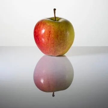 Beautiful apple on a surface with reflection Stock Photos