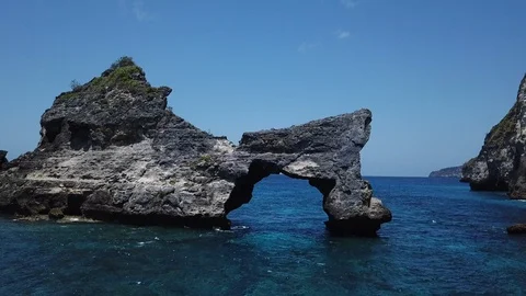 Beautiful Arch Shaped Cliff in Shallow Ocean Water [Drone Footage] Stock Footage 96283574
