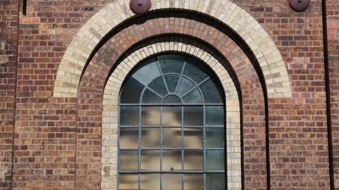 Beautiful arched factory window and surrounding brickwork from nineteenth Stock Footage 345627604
