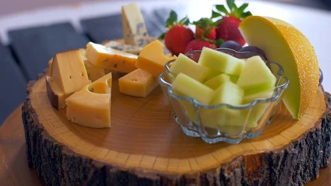 Beautiful arrangement of different types of cheeses on a wooden board Stock Footage 109128558