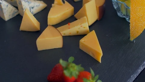Beautiful arrangement of different types of cheeses on a black stone Vídeo Stock 109129045
