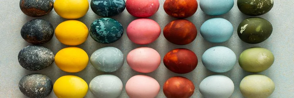 A beautiful array of hand-dyed Easter eggs in various colors, neatly arranged Stock Photos