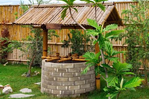Beautiful artesian well made by bricks and old vintage style wooden dipper .. Stock Photos