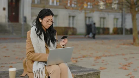 Beautiful Asian Customer Using Credit Card and Laptop Wearing Earphones. Girl Stock Footage 237603847
