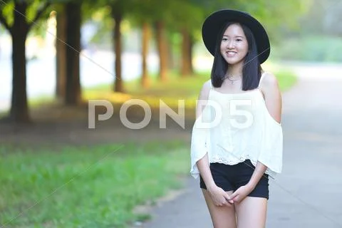 Beautiful Asian woman in a hat looks into the camera portrait Stock Photos