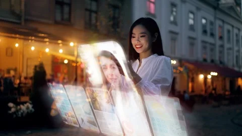 Beautiful Asian woman using an augmented reality phone to communicates via Stock Footage 248139423