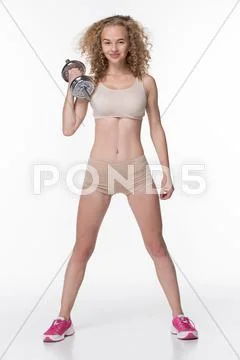 Beautiful athletic girl standing with dumbbells Stock Photos