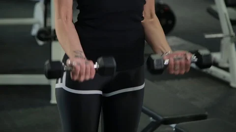 Beautiful athletic young girl trains dumbbells biceps in the gym. Stock Footage 103395053