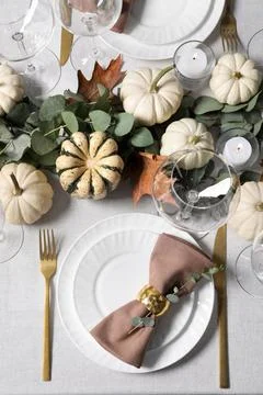 Beautiful autumn table setting. Plates, cutlery, glasses, pumpkins and flor.. Stock Photos
