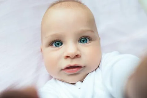 Beautiful baby with gorgeous blue eyes lying on his back Stock Photos