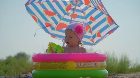 Beautiful baby playing in the pool in summer Stock Footage
