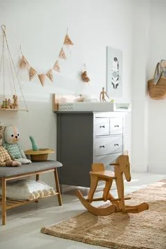 Beautiful baby room interior with toys and modern changing table Stock Photos