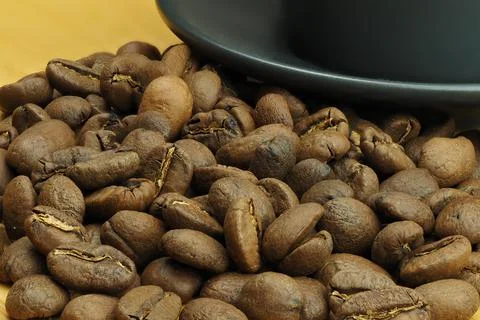 Beautiful background and coffee beans and a coffee cup in the background. Stock Photos