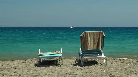 Beautiful background of a calm sea. In the foreground are two empty loungers. Video stock 111908376