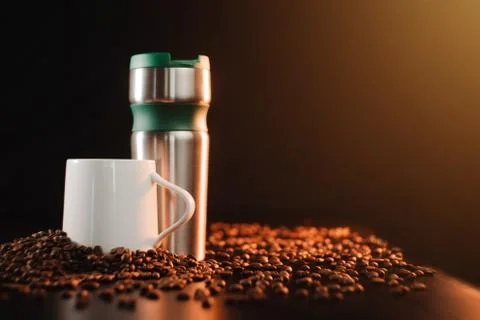 Beautiful background layout of a coffee cup and thermo mug on a dark gold bac Stock Photos