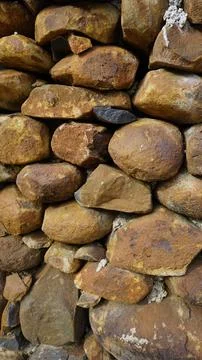 Beautiful background pattern image of a wall made of round stone red color ro Stock Photos