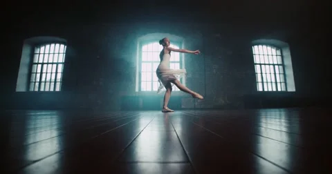 Beautiful ballerina in white dress performs pirouettes in the Studio, slow Stock Footage