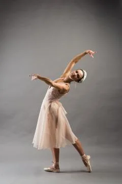Beautiful ballet dancer posing on pointes on light grey studio background Stock Photos