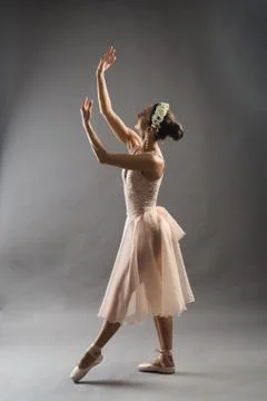 Beautiful ballet dancer posing on pointes on light grey studio background Stock Photos