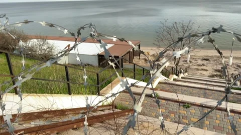 Beautiful beach blocked by harsh wire fence, restricting access to water Stock Footage 272595231