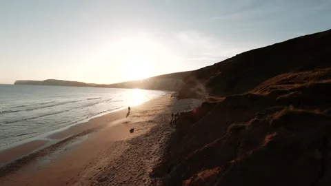 A beautiful beach with a cliff in the background Stock Footage 298248618